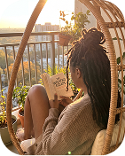 Woman relaxing in a hanging chair on her balcony